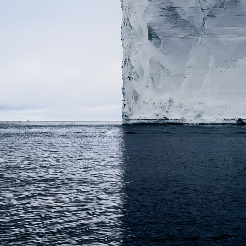 Towering Antarctic tabular iceberg and its shadow splitting the ocean into quadrants, photographed by David Burdeny for the N