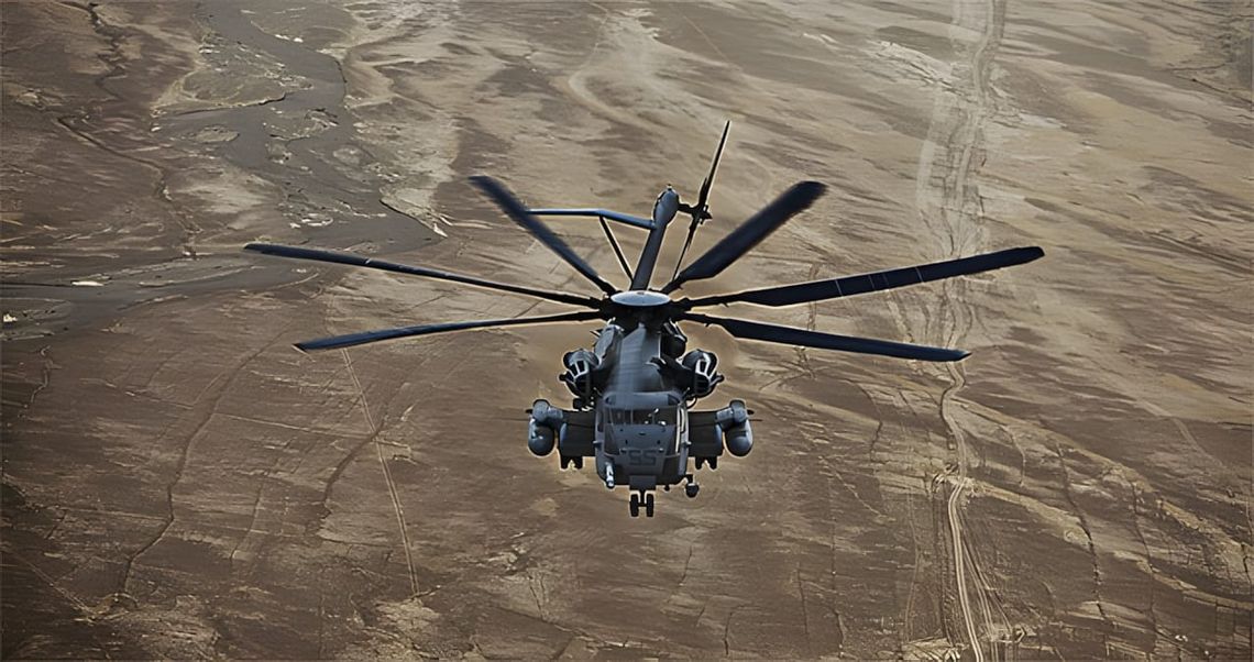 Sikorsky MH-53 Pave Low helicopter photographed head-on from above, flying low over arid brown desert terrain; FLIR turret, a