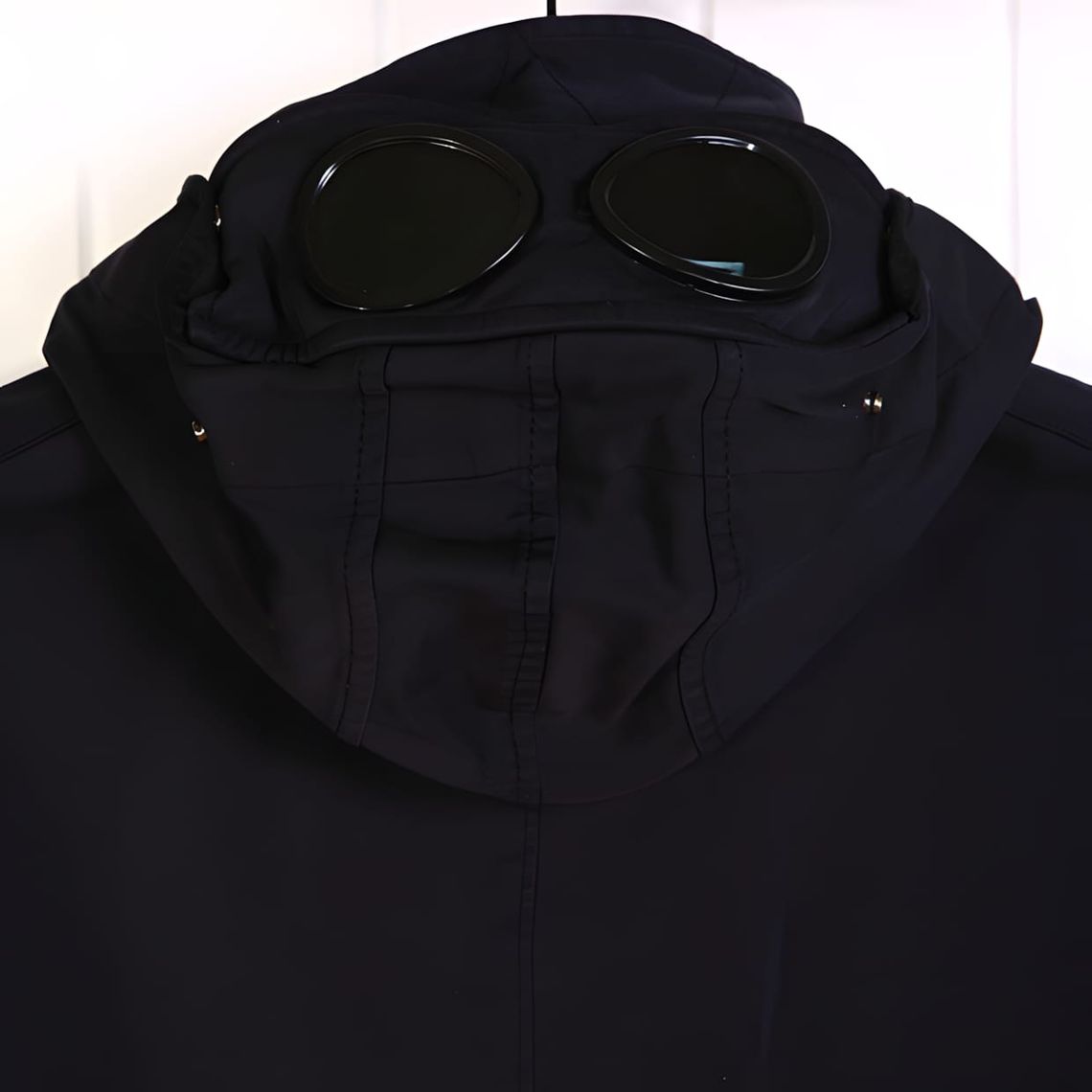 C.P. Company Shell-R Goggle Gilet in navy, close-up of goggle hood with black circular lenses and zip placket.