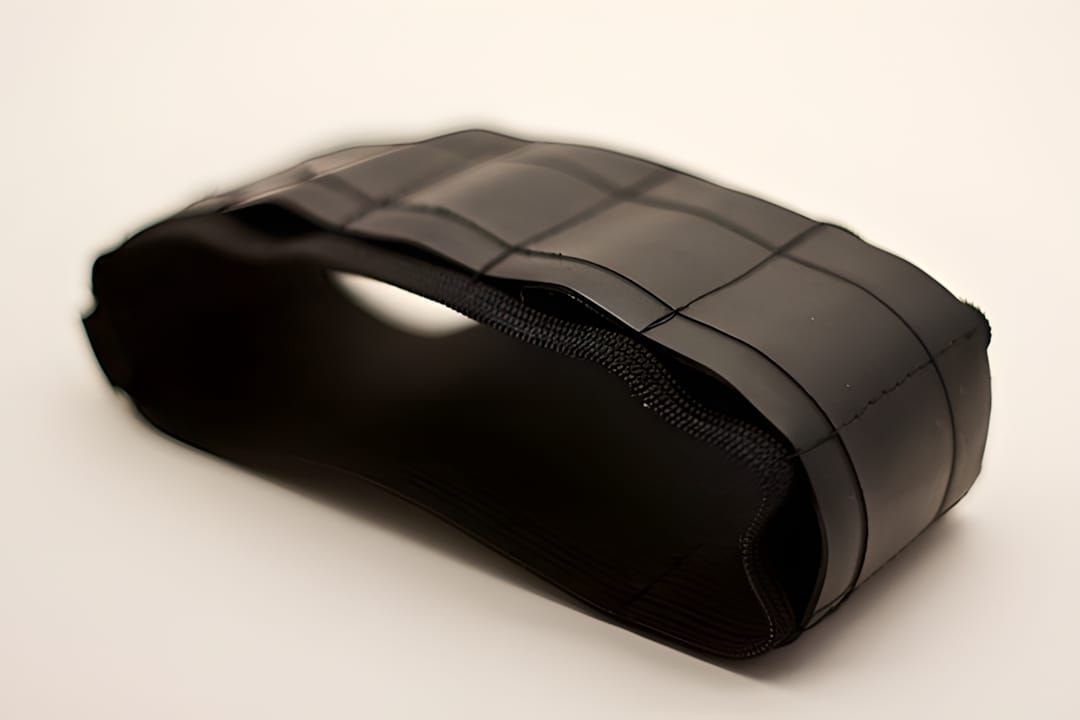Cleverhands Journal Bandolier — a pen holder made from reclaimed bicycle inner-tube rubber strapped around a notebook, showin