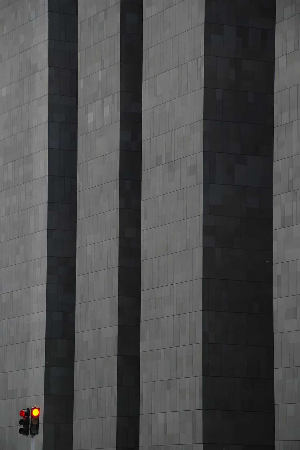 Close-up street-level photograph of the CBS Building facade, showing dark grey-black Canadian granite cladding divided by dee
