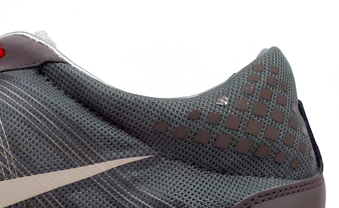 Nike Lunarfly+ 2 Trail heel quarter panel in dark grey mesh with debossed dot grid collar and silver swoosh, red accent at co
