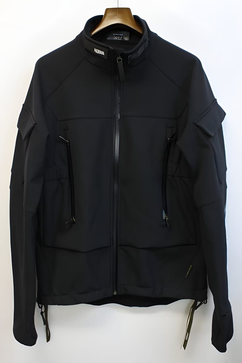 ACRONYM black softshell jacket on hanger, showing bilateral arm pockets, angled chest zips, and stand collar.
