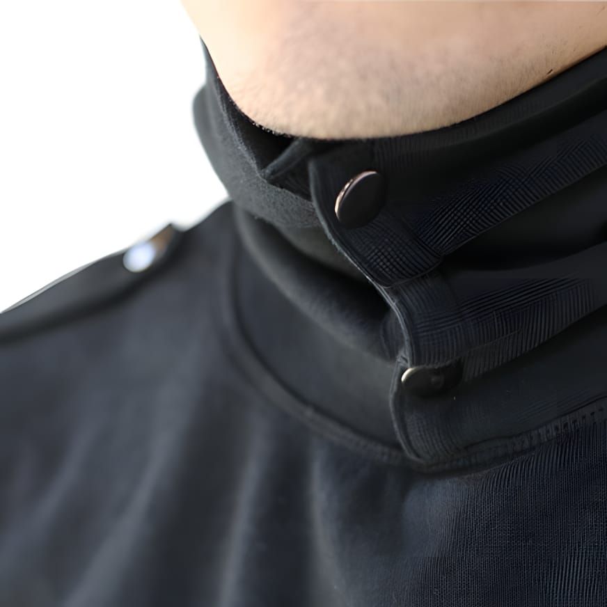 Close-up of a black sweatshirt with a high snap-button funnel collar, worn by a model against a white background.