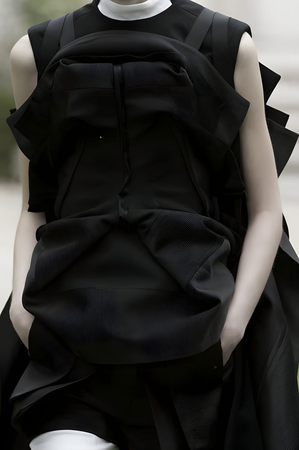 Junya Watanabe runway look in dark structural silhouette with engineered fabric construction