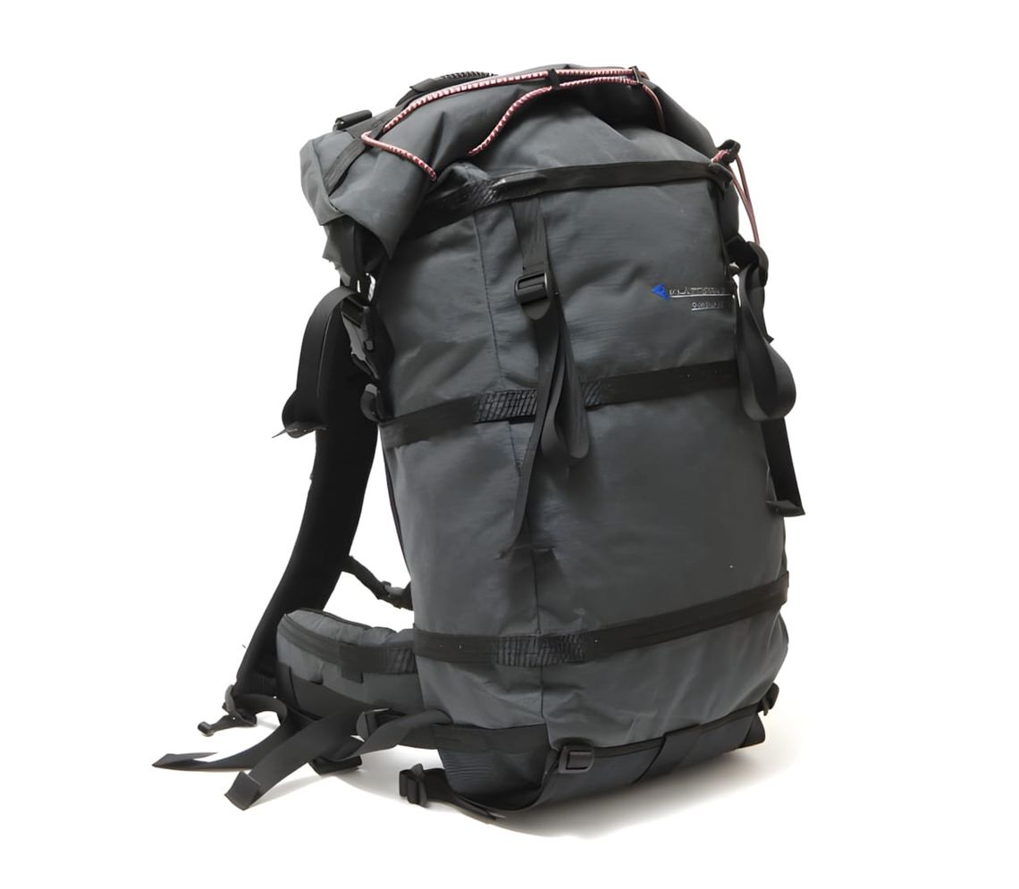 Klättermusen Gungner 50L backpack in charcoal, showing the roll-top closure, minimal exterior, and load-control straps.