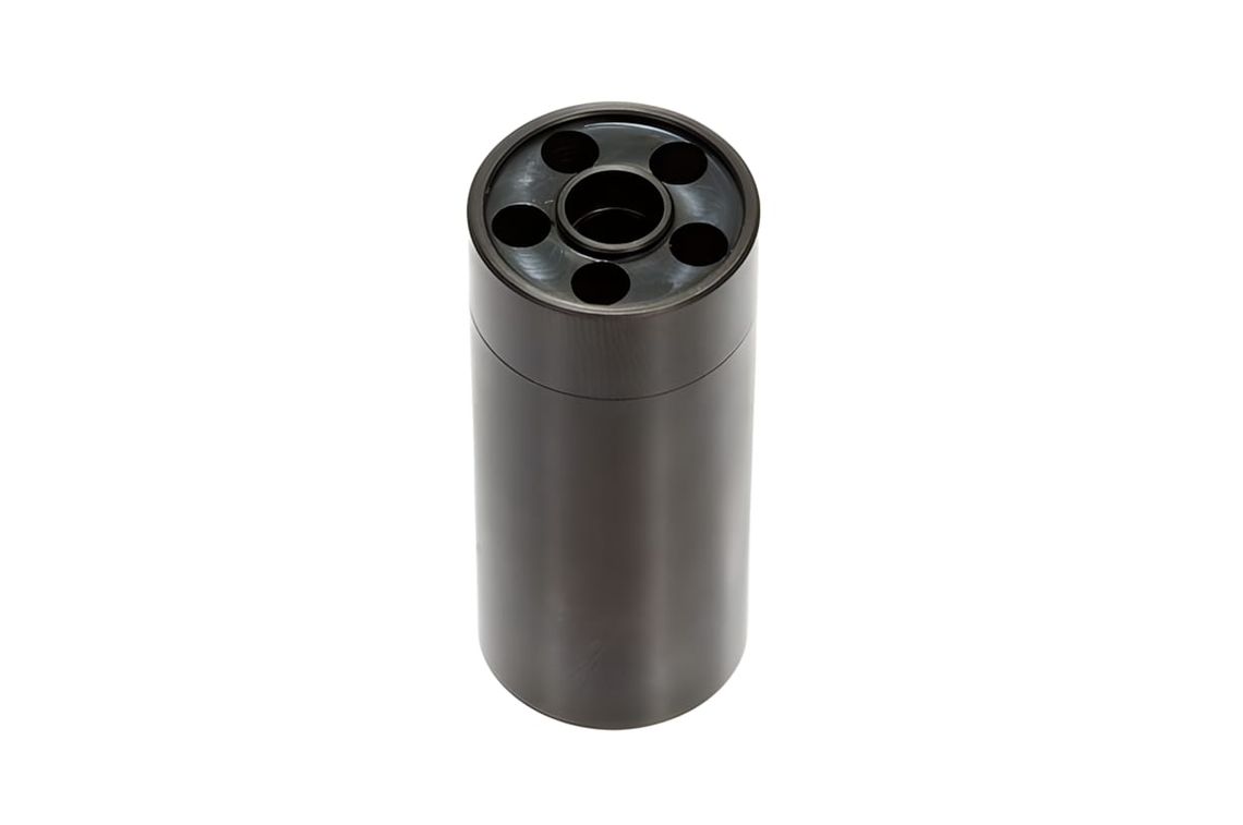 Matte black cast-aluminum revolver cylinder pen holder, viewed from above at three-quarter angle on white background.
