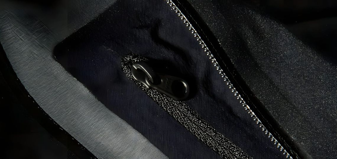 Close-up of a black Gore-Tex shell jacket showing a riri zipper detail, Visvim Hadrian 3L.