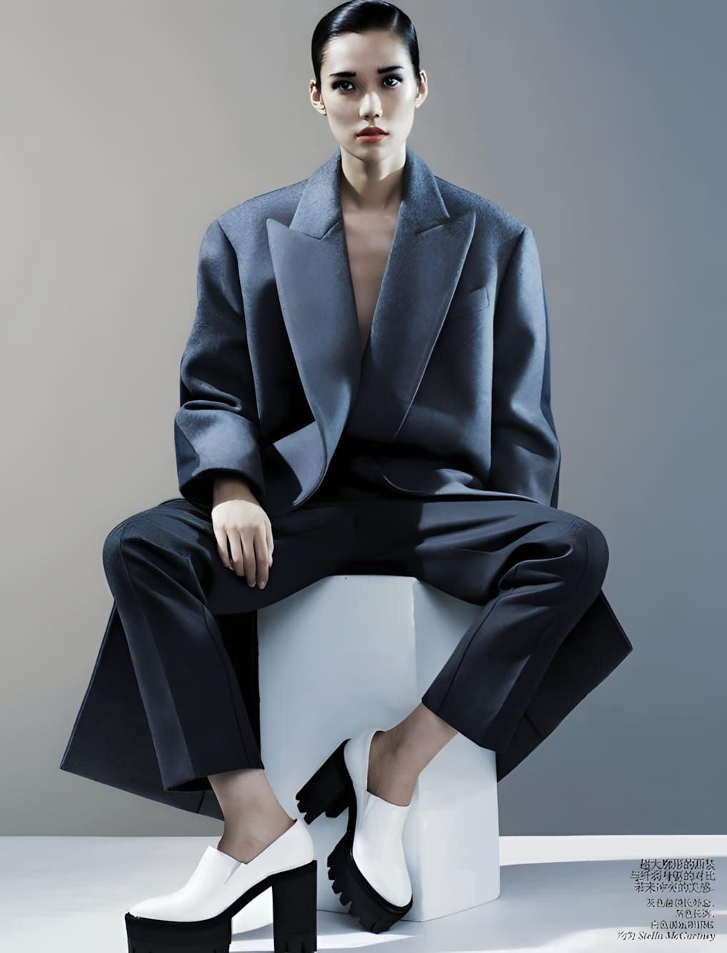 Tao Okamoto in a black pinstripe suit and skirt, photographed by Josh Olins for Vogue China August 2013