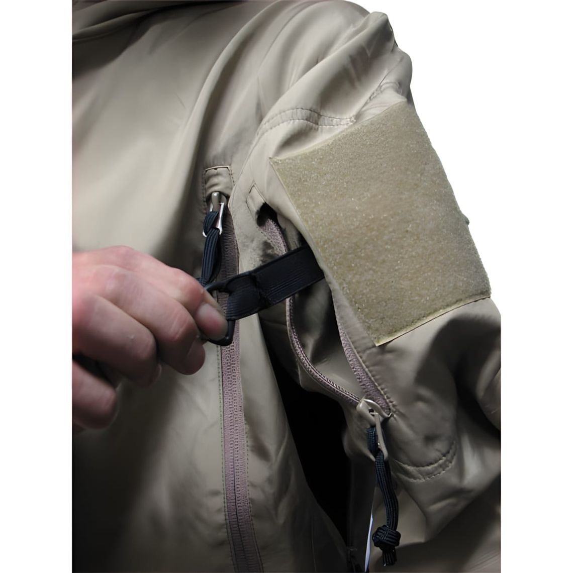 Close-up of a coyote tan TAD softshell jacket sleeve showing a large square velcro patch panel and front zip detail.