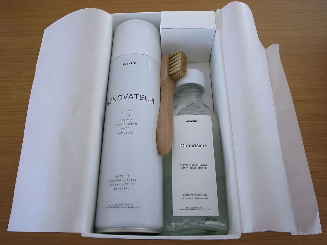 Visvim suede and shoe care kit open in a white presentation box: a white aerosol Renovateur spray canister on the left, a gla