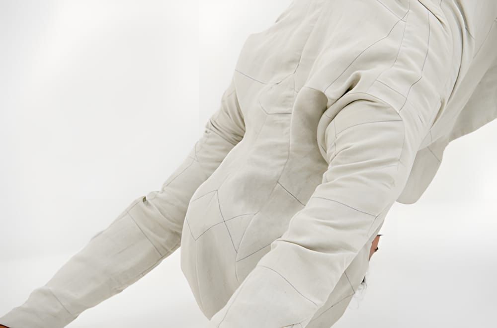 Devoa off-white panelled jacket, close-up of geometric seam construction across back and sleeve.