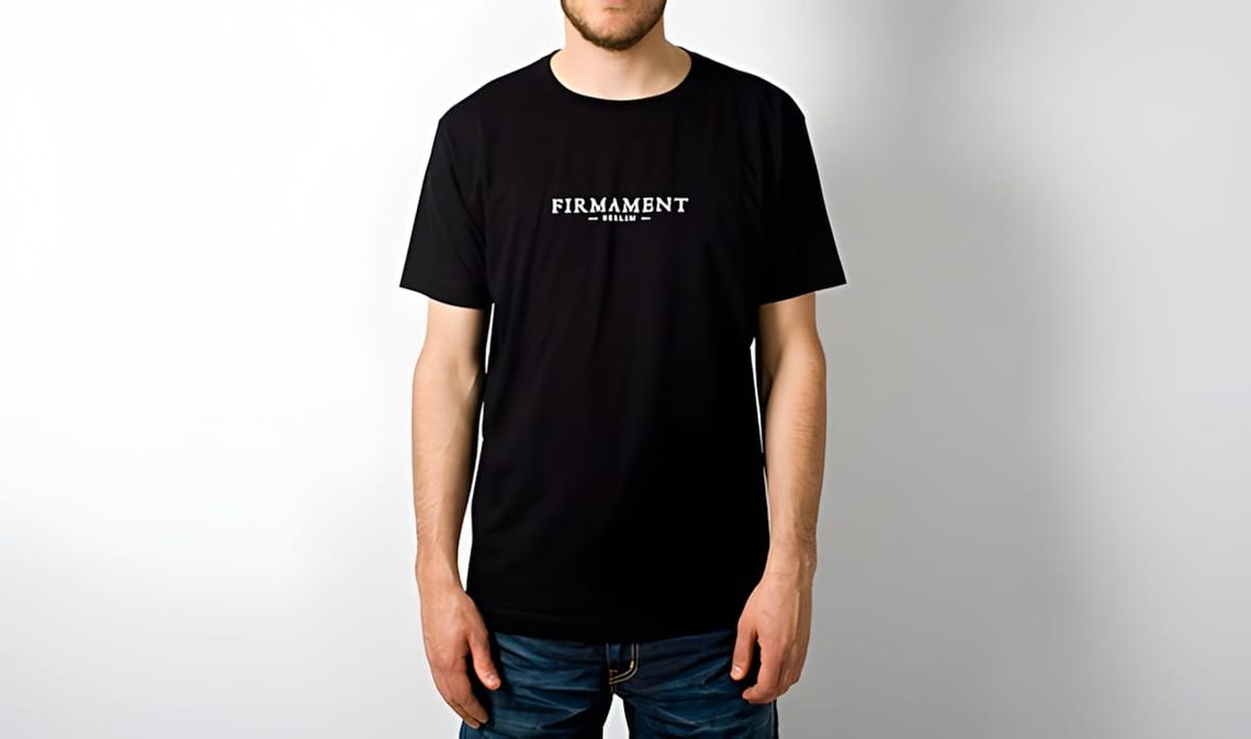 Male model wearing a black Firmament Berlin 5th Anniversary crew-neck tee with white collegiate wordmark on chest.