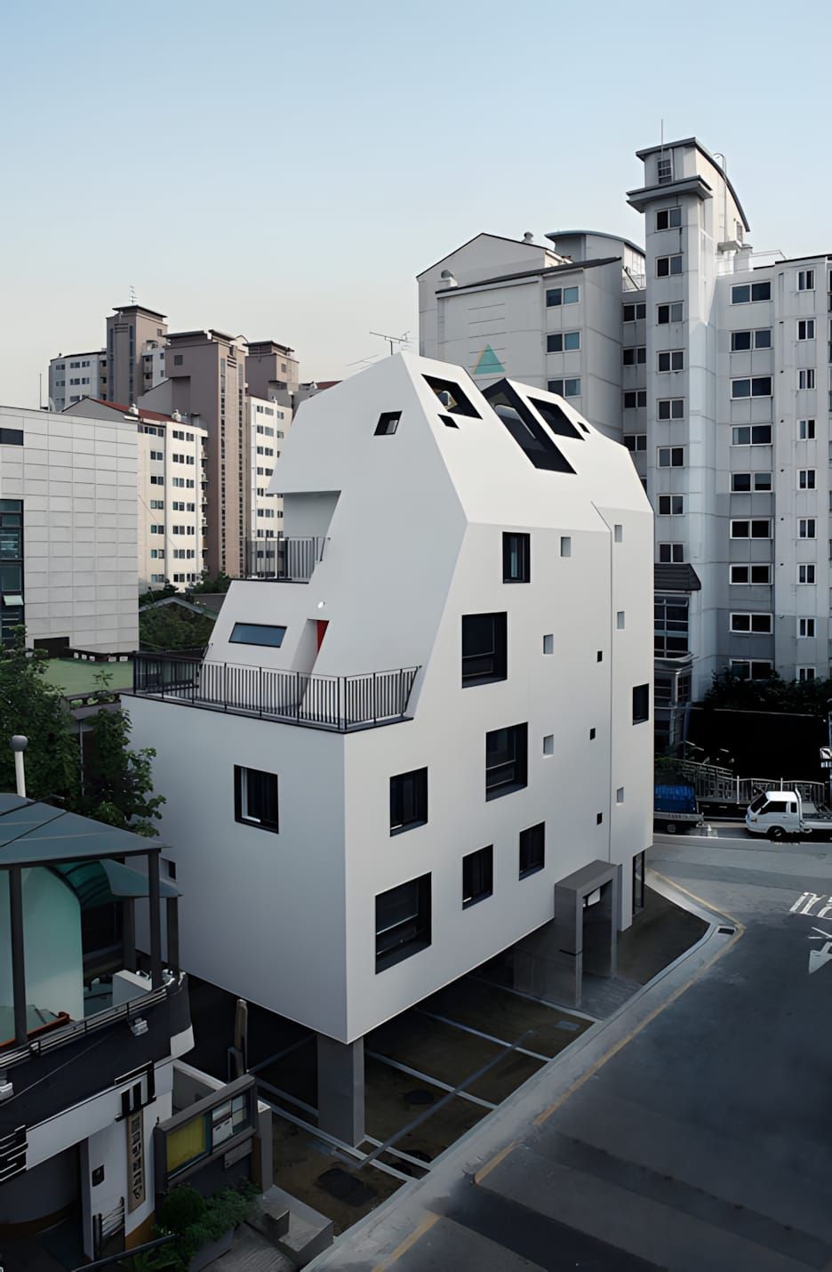 Overhead three-quarter view of the Design Band YOAP White House in Seoul — a compact five-storey white concrete residential b