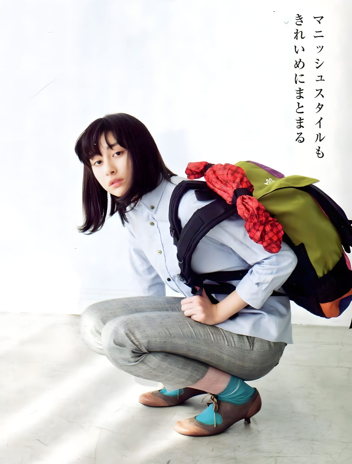 Akari Hayami crouching in a Japanese fashion magazine editorial: light blue chambray button-down shirt, grey slacks, teal soc