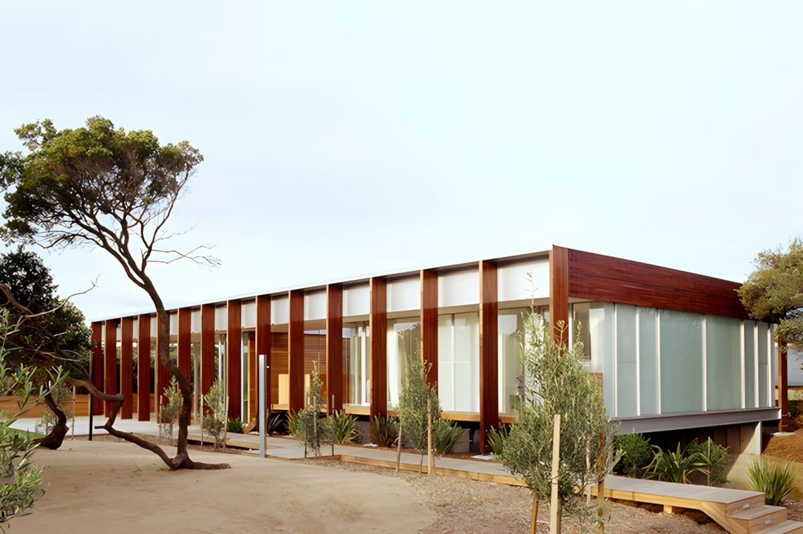 Exterior view of Peninsula House by Watson Architecture + Design, Portsea, Victoria — a low horizontal pavilion with warm red