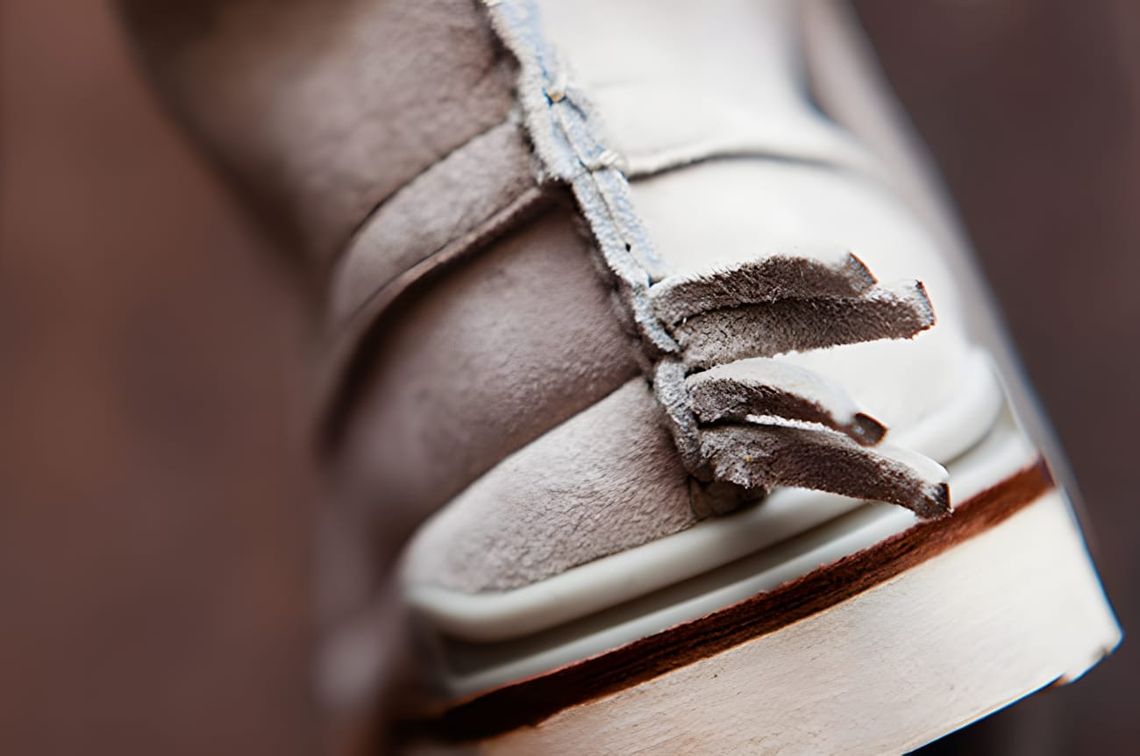 Visvim Moc-Folk 'Gris' SS11 — close-up of light grey suede moc-toe fringe lacing and cream rubber sole.