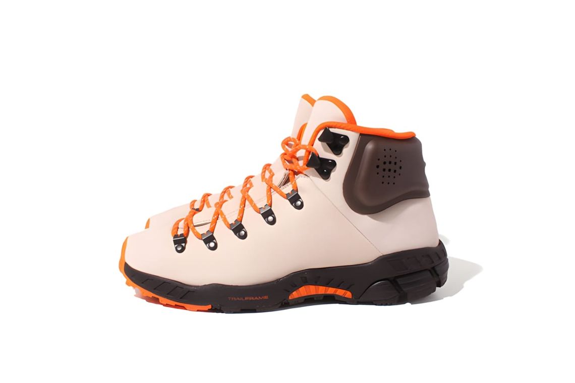Nike ACG Zoom Meriwether hiking boot in ivory/cream with bright orange laces, orange TrailFrame outsole accents, and dark bro
