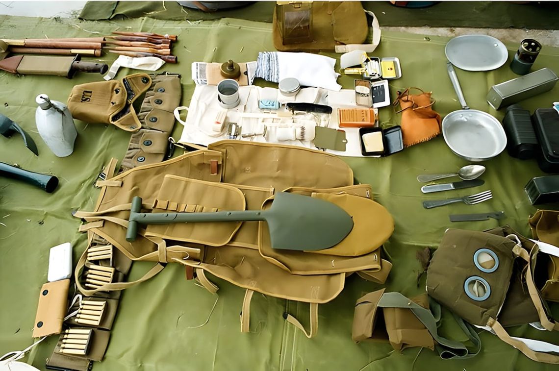 US Army M-1943 folding entrenching tool with wood handle and olive drab painted metal blade, shown folded for carry — a WWII-