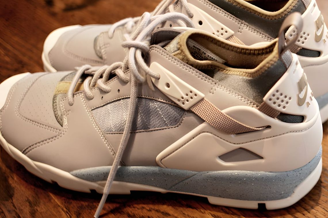 Pair of Undercover × Nike ACG Air Revaderchi low-top sneakers in light grey and silver, showing the Huarache-style webbing st