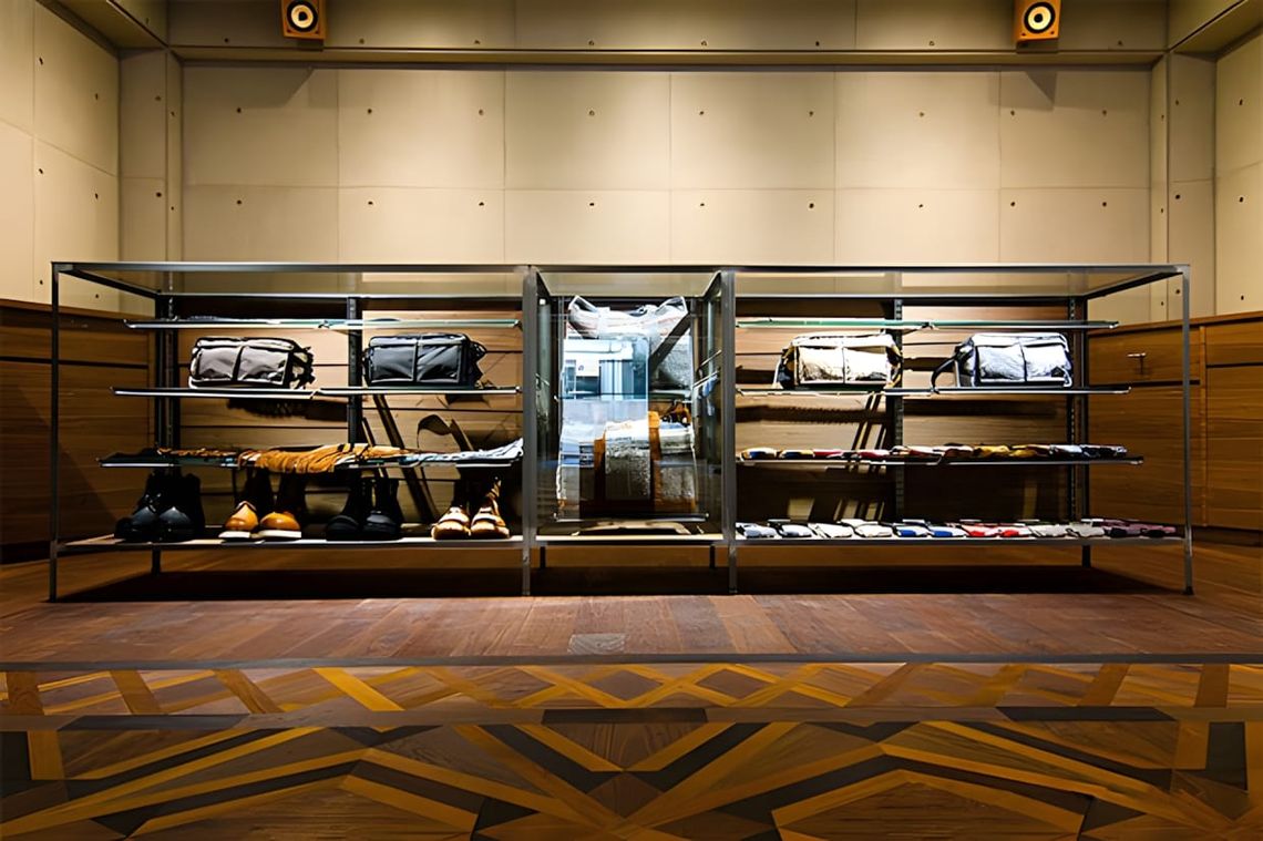 Interior of the White Mountaineering Tokyo flagship store, showing the architectural space and a preview of the brand's curre