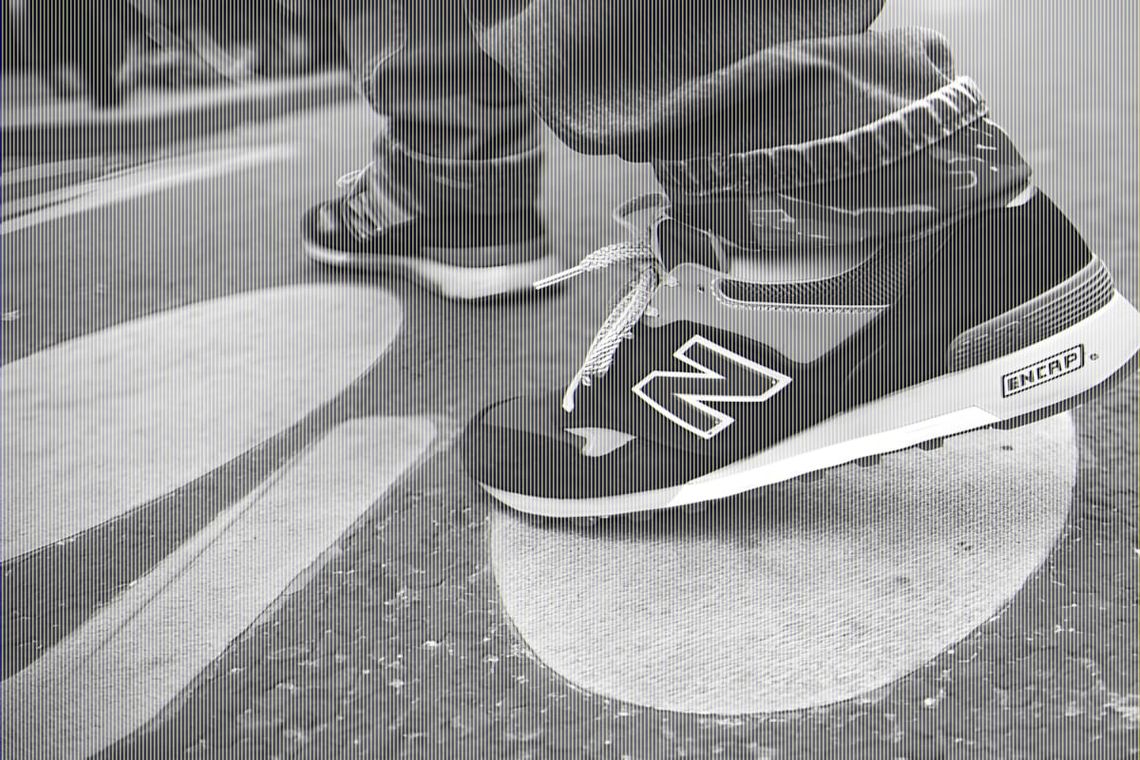 On-foot view of New Balance M577NG in navy suede and grey mesh, shot on pavement, Fall 2011