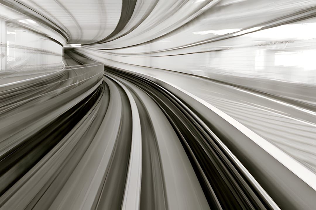 Front-cab view of Yurikamome monorail curving through concrete tunnel, warm sepia motion blur.