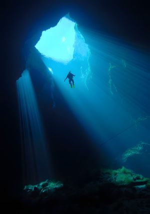 Cave Diving — Diver in Cenote Light Rays