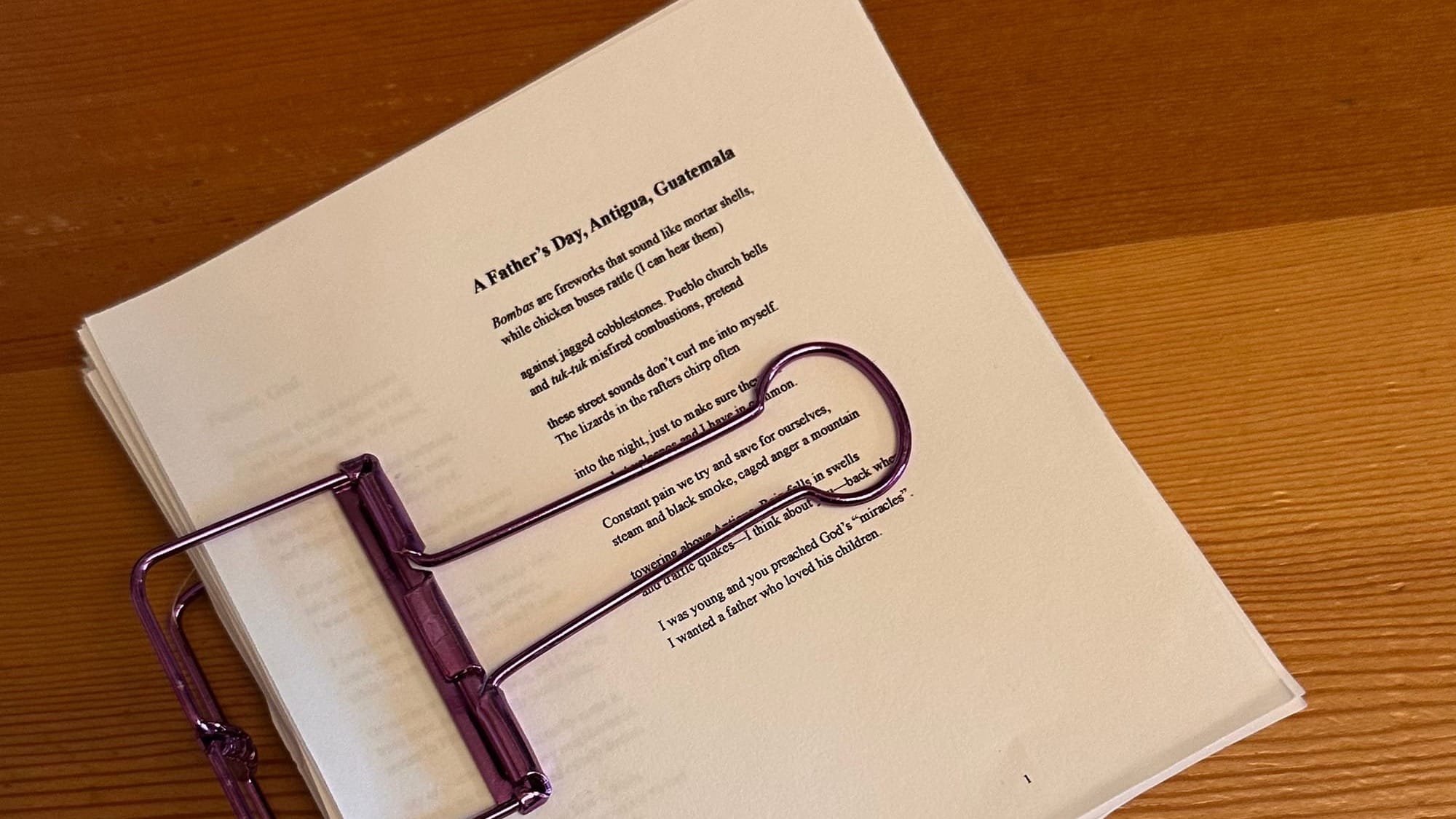 A stack of poems bound together with a purple binder