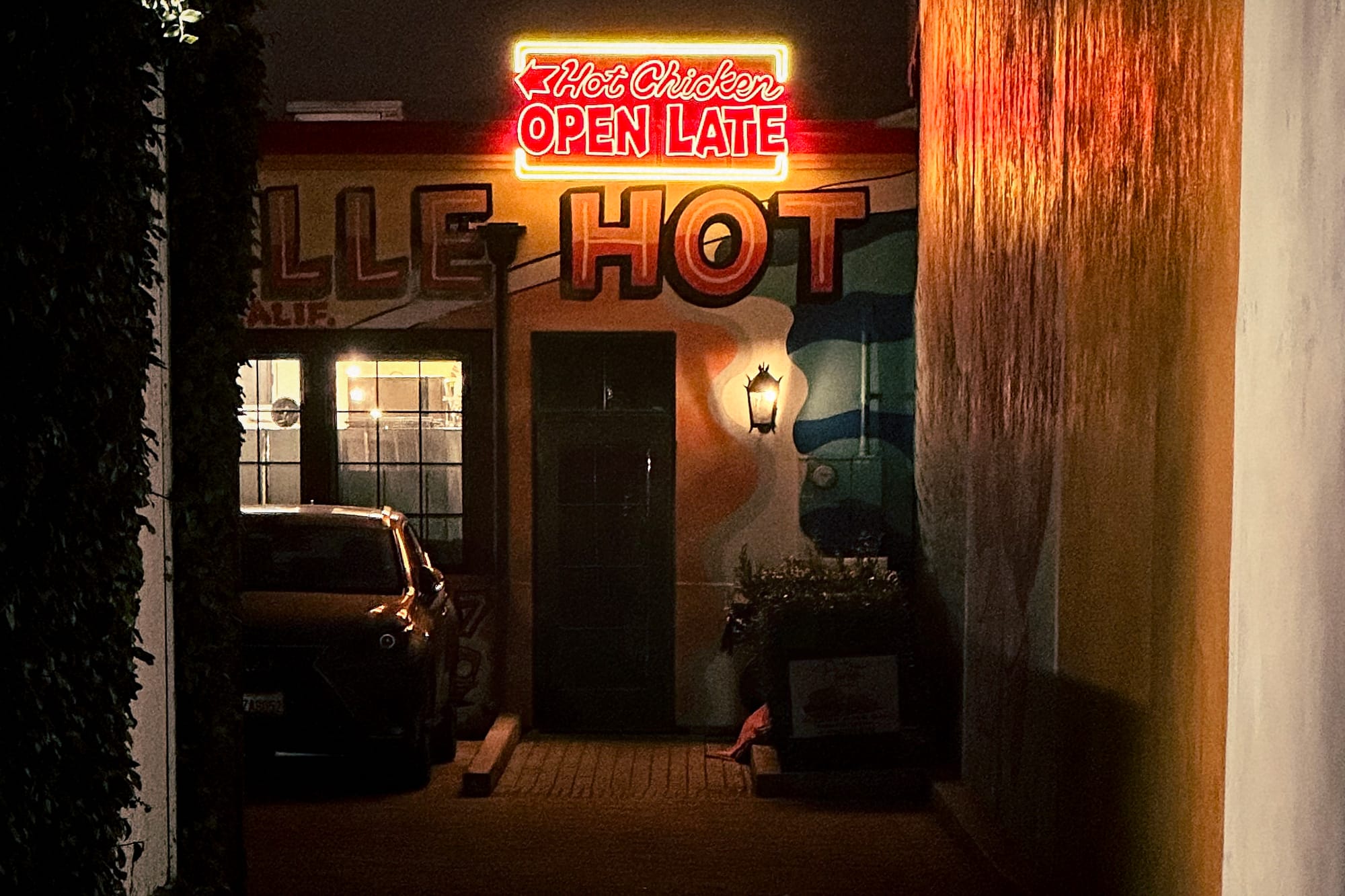 a neon sign that says "hot chicken open late"