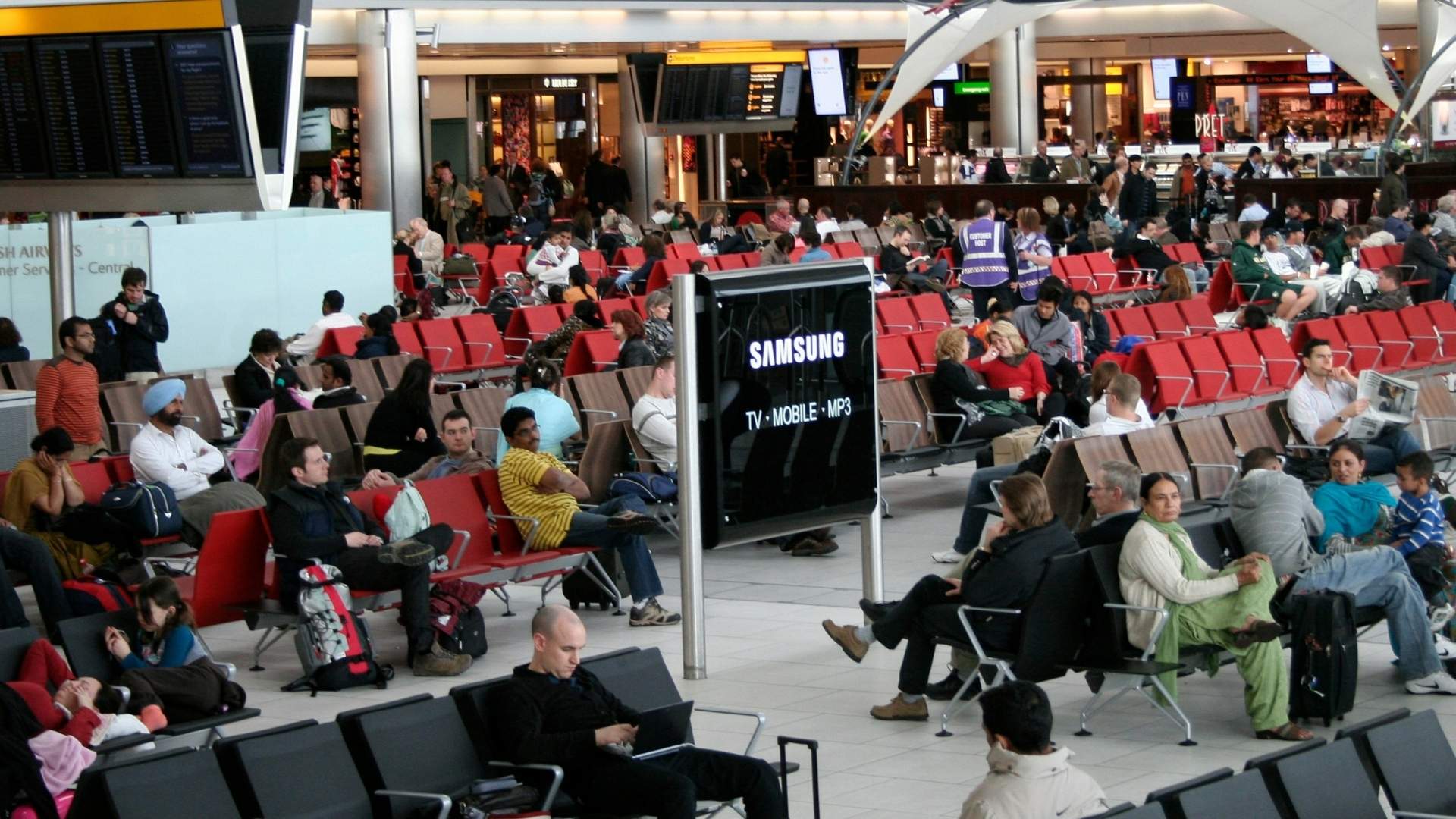 Crowded airport as passengers wait due to delays and bottlenecks.