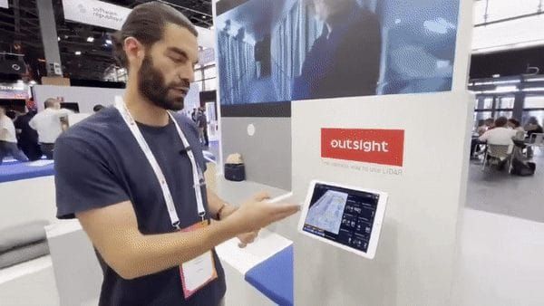 Outsight team member Erwan Le Roux demonstrates a LiDAR-powered interface on a touchscreen at a tech exhibition, showcasing real-time spatial analytics