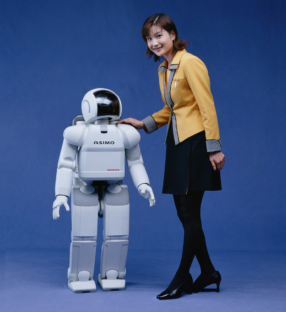 Honda ASIMO humanoid robot walking, white body with a black visor, 2000
