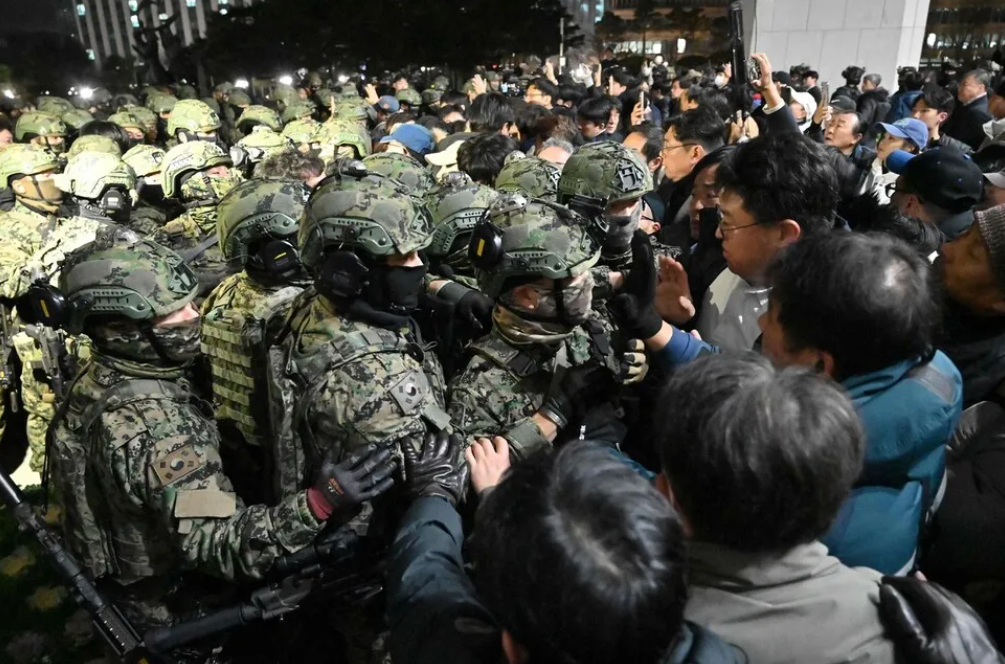 2024년 12월 3일 국회의사당에서 시민들과 국회 보좌진들이 계엄군을 막고 있다