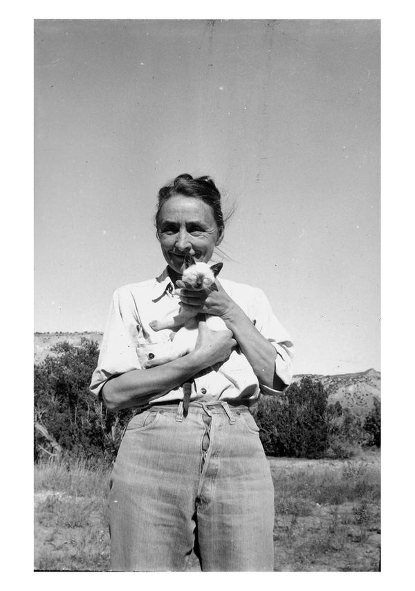 Georgia O'Keeffe holding a sweet Siamese kitten and looking very happy