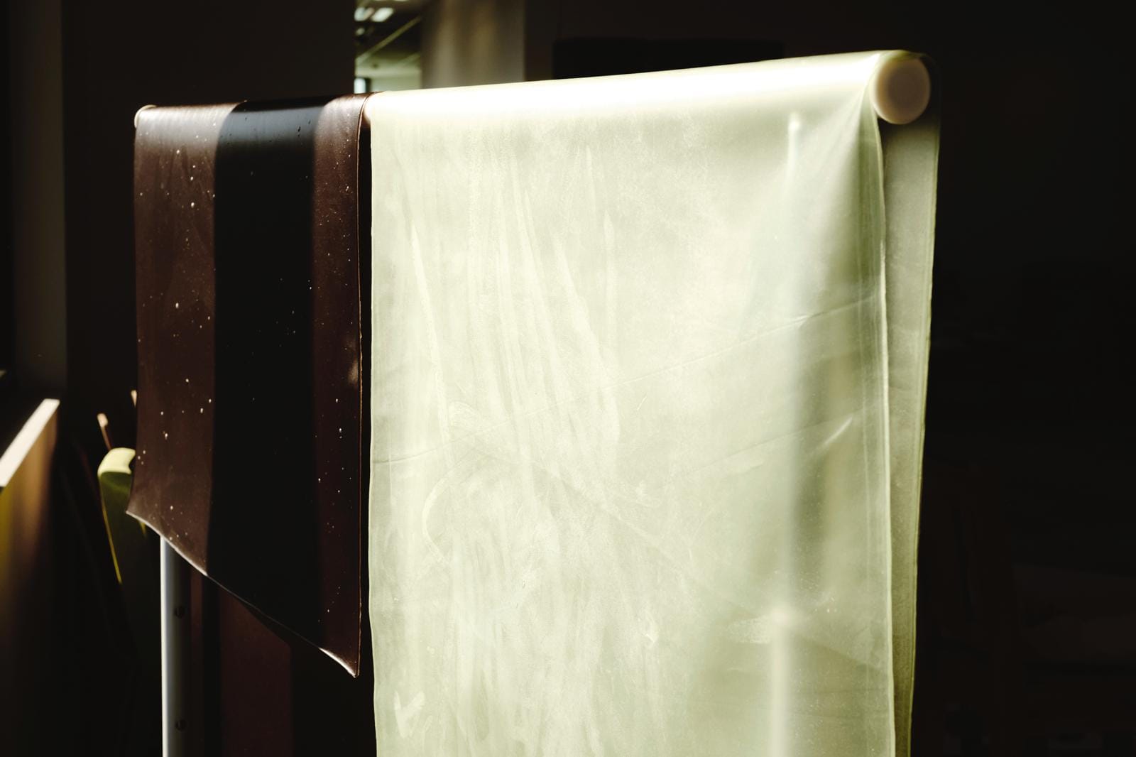 Seaweed biomaterial with natural coloring, prefabricated material hanging on rack in studio.