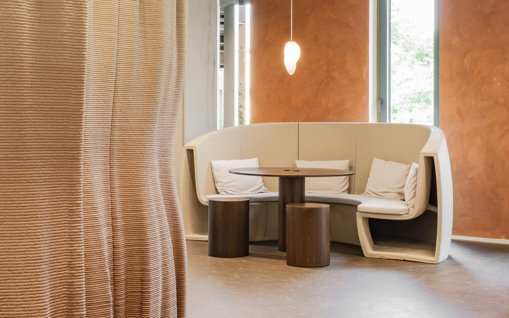 Silversquare Co-Working Space by Lilian van Daal. Photography by Save as Studio. 3D printed, fitted, sand colored office furniture and dark wooden round table with stools.