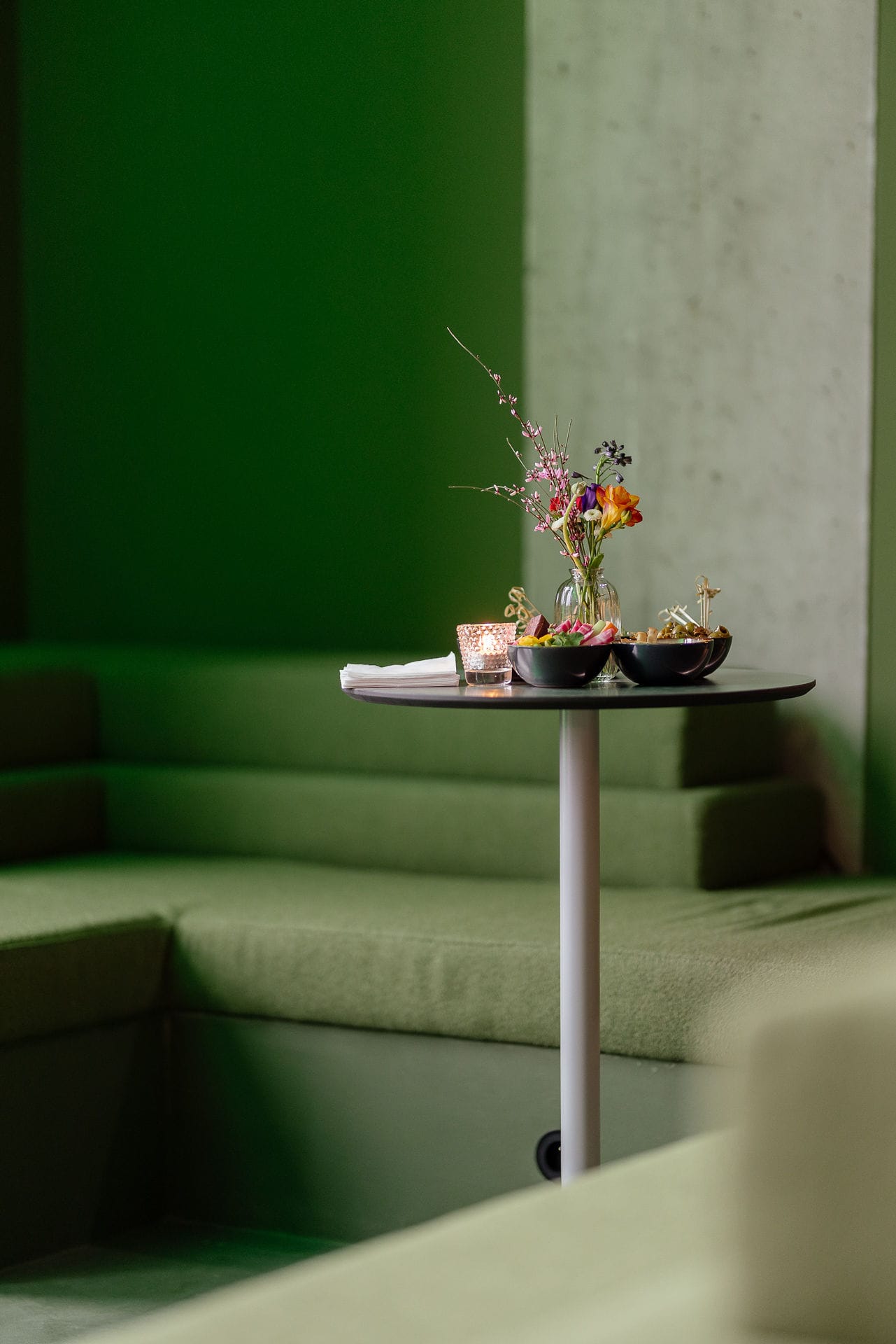 Silversquare Co-Working Space by Lilian van Daal. Photography by Safe as Studio. Forest green sitting area with bouquet and snacks.