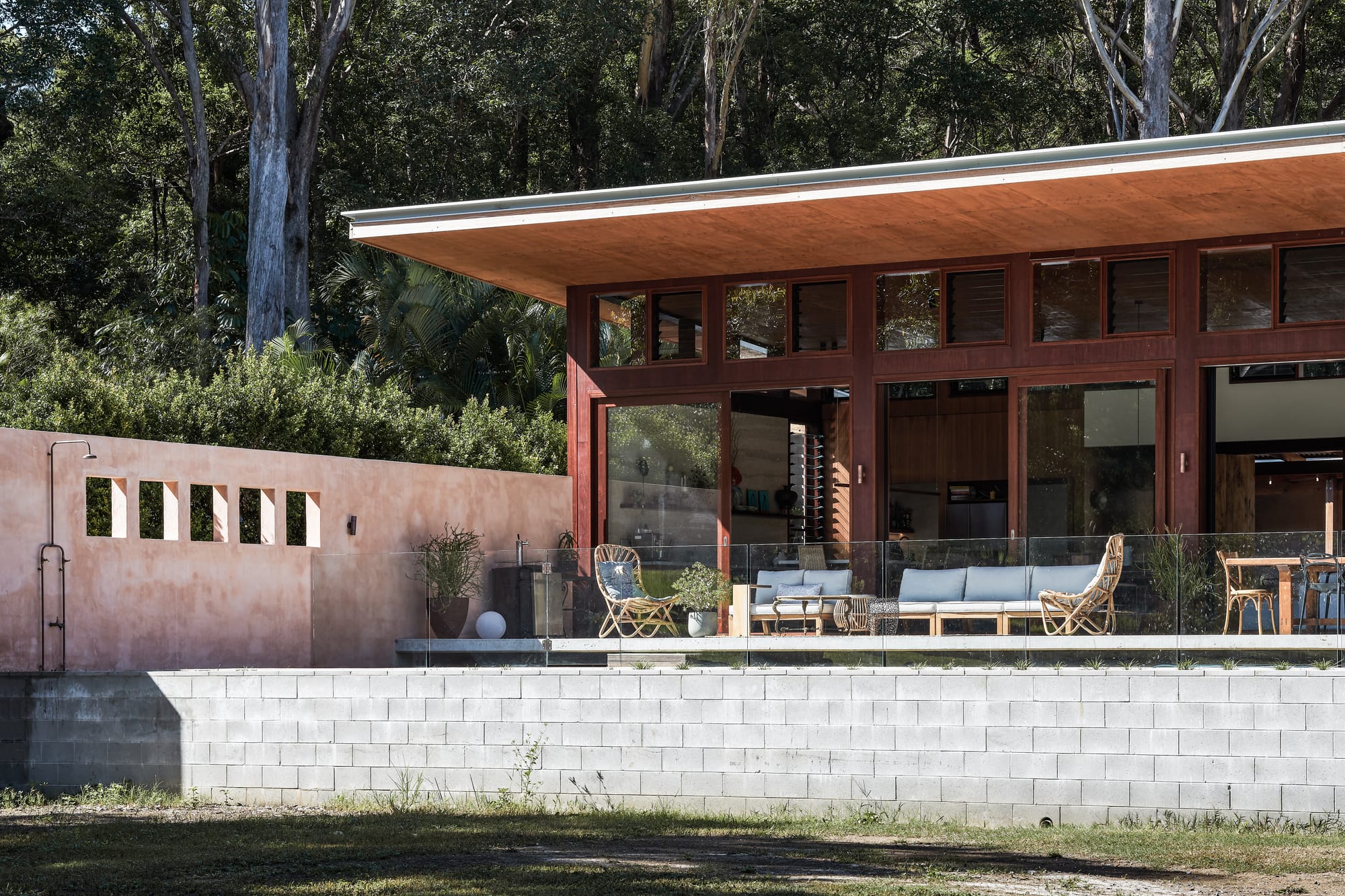 Outside view on modern tropical family home with wooden facade and flat roof.