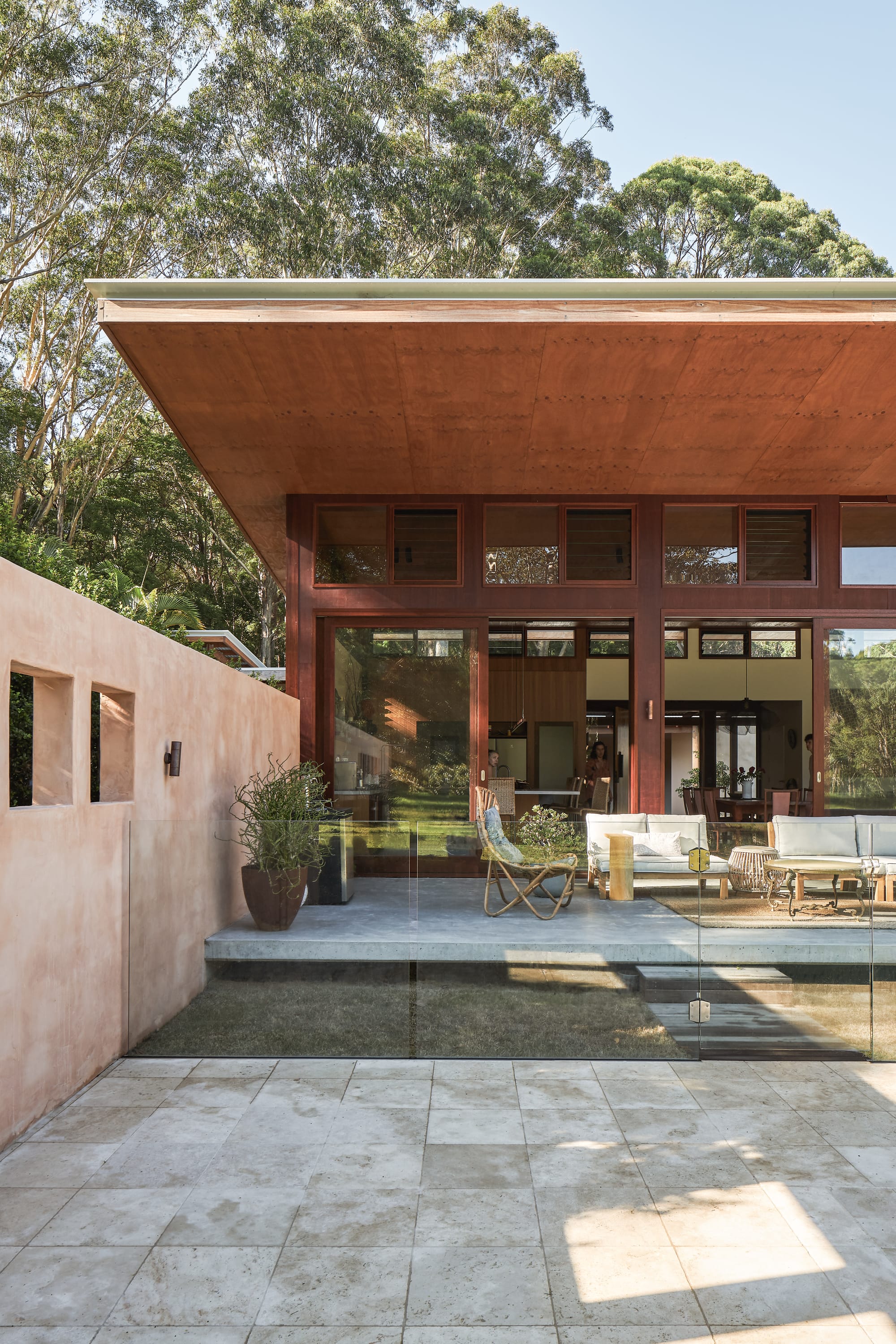 Outside view on modern tropical family home with wooden facade and flat roof.