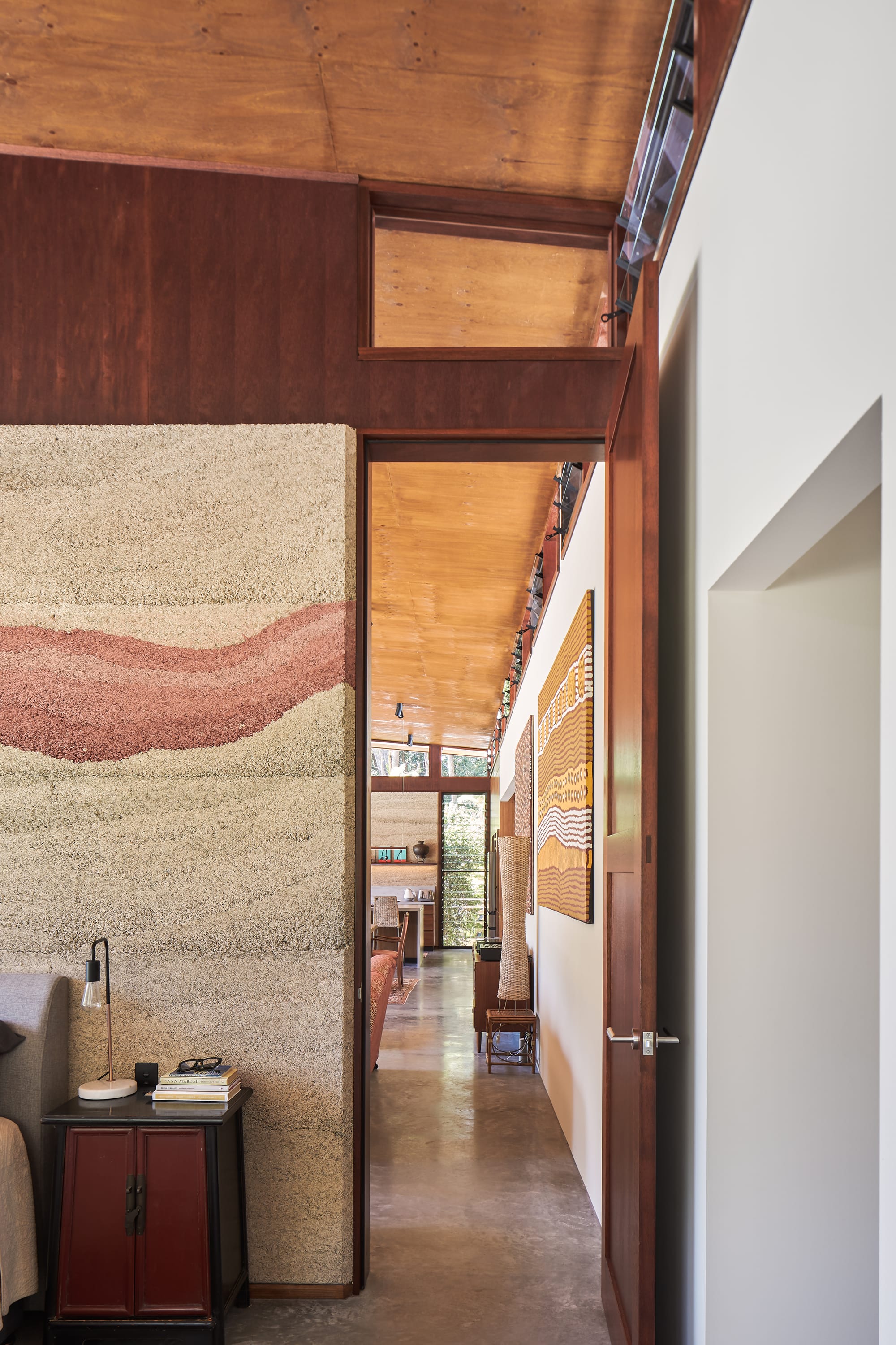 Modern, nature inspired interior in earthy hues aboriginal art and hempcrete walls.