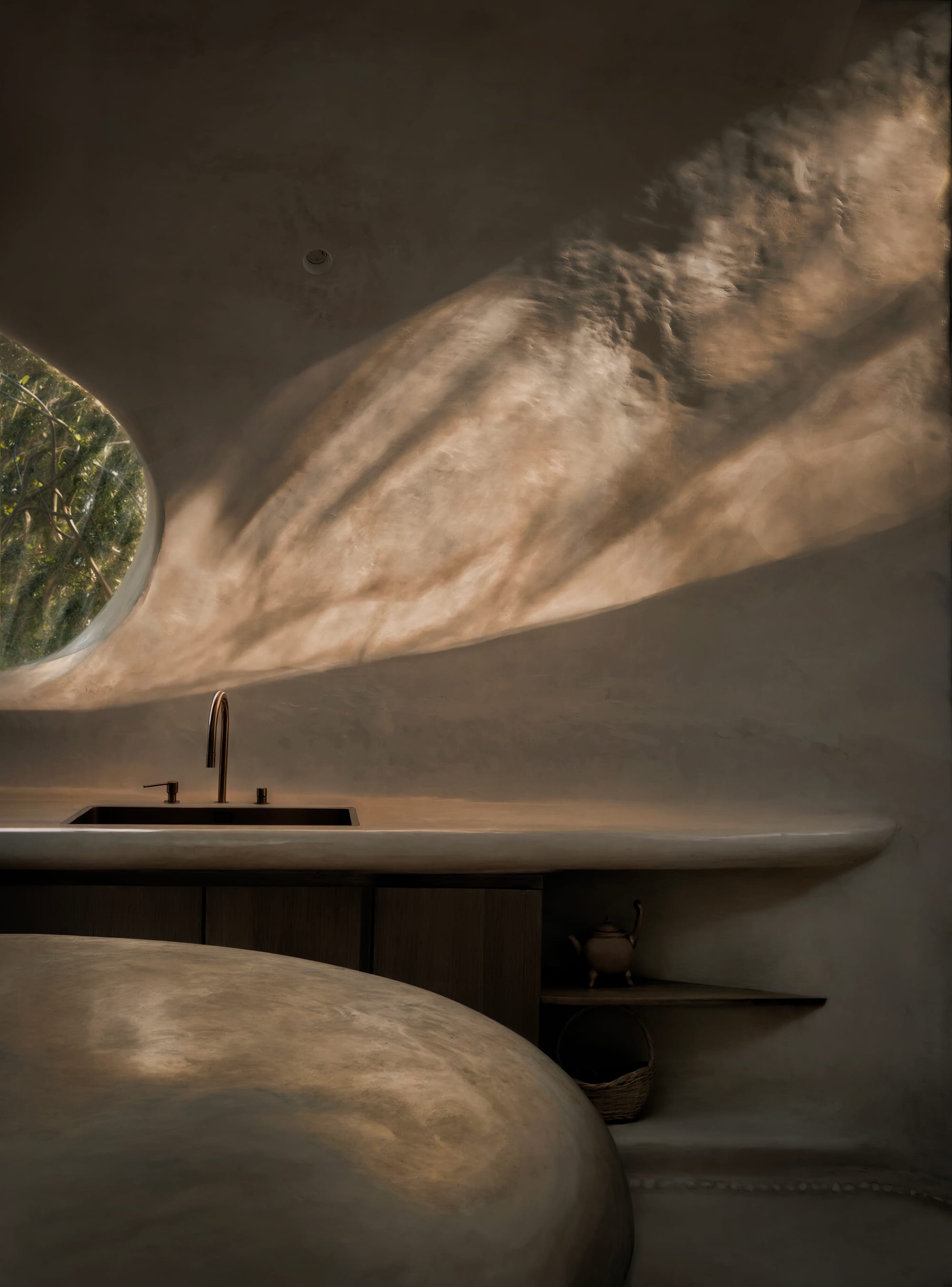 Organically shaped and seamless integrated kitchen with beautiful natural light and Tadelakt finish.