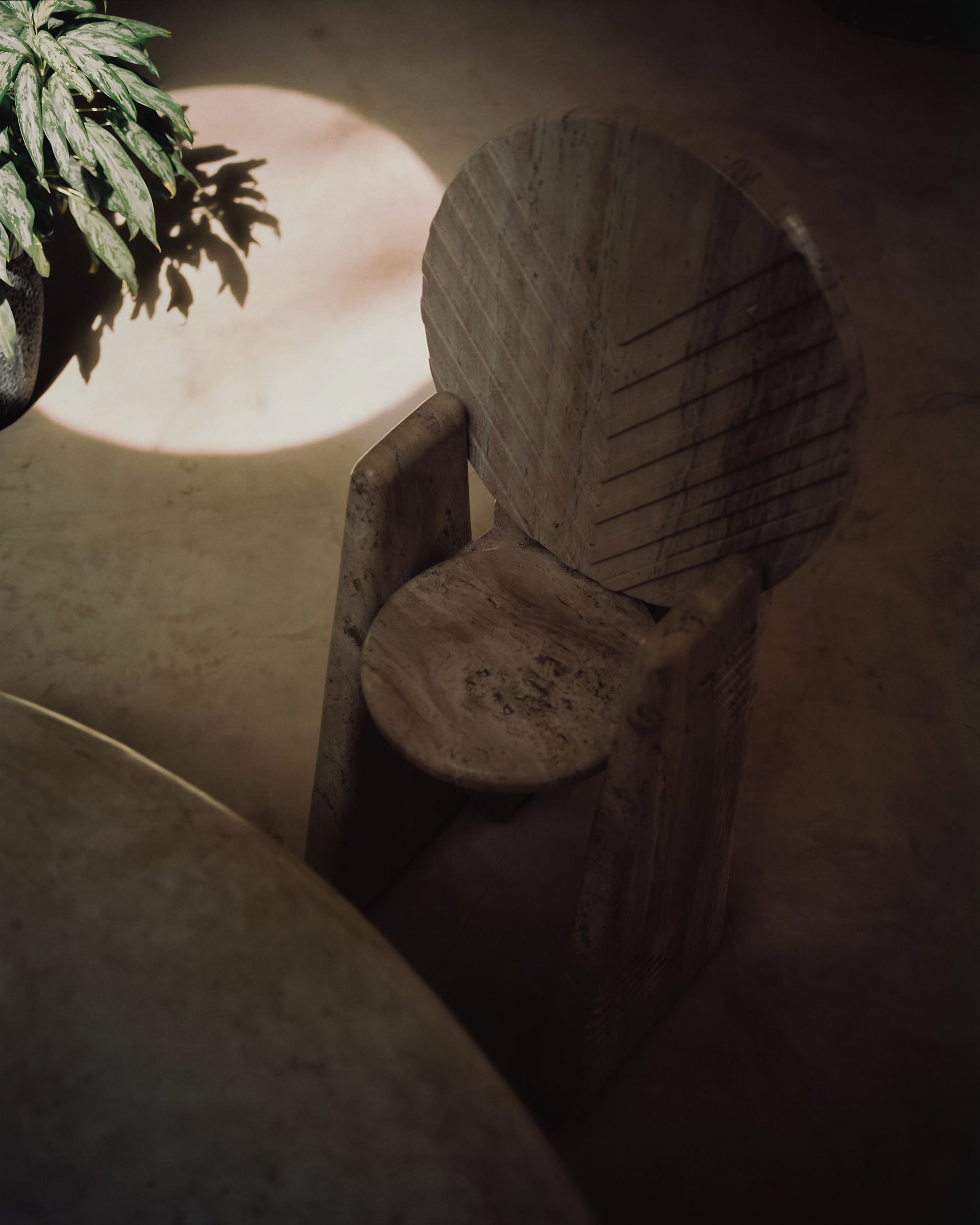 Stone chair in monolithic interior and beautiful natural light.