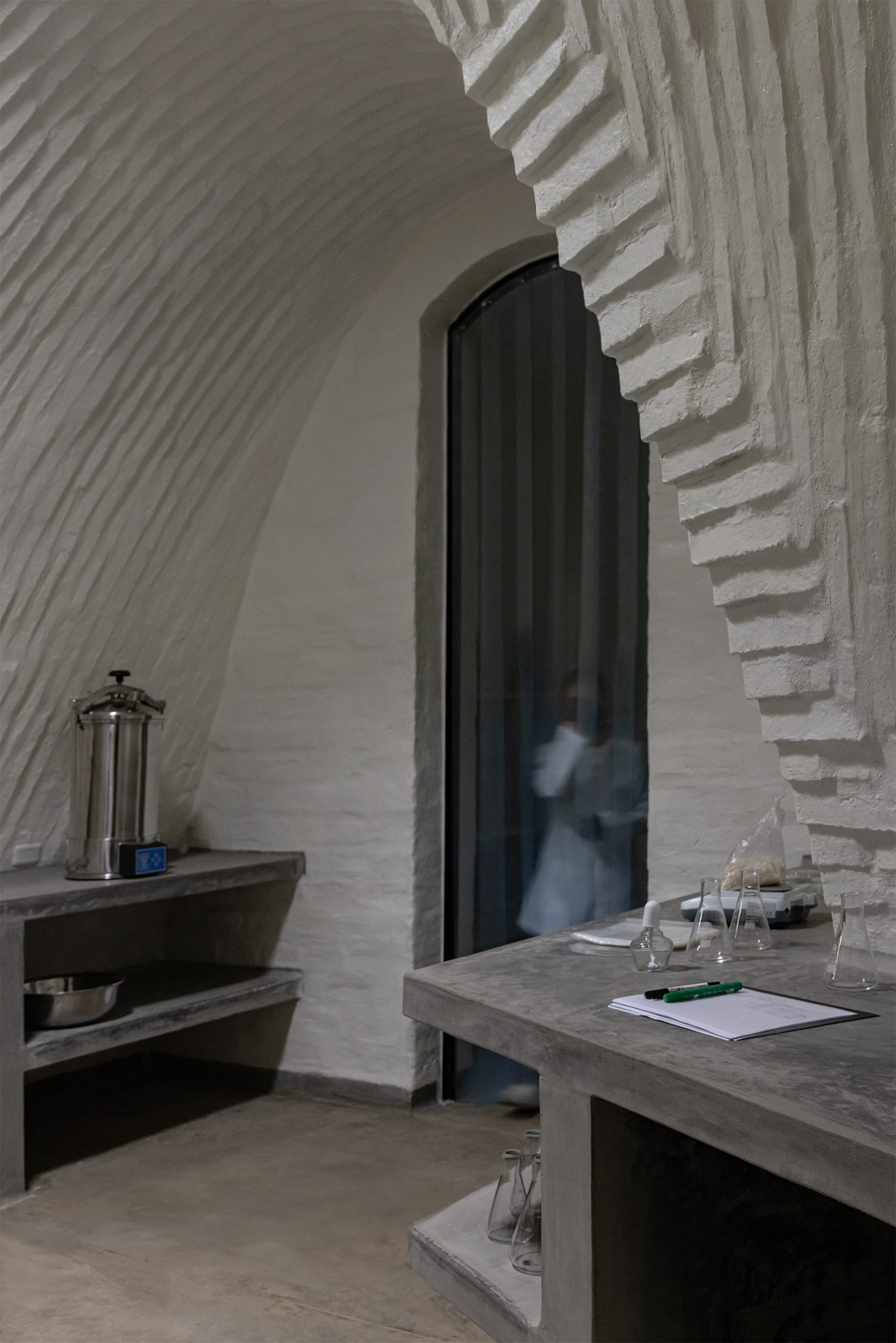 Interior view to brick constructed, white painted arches with concrete work tops and splash guard curtain.