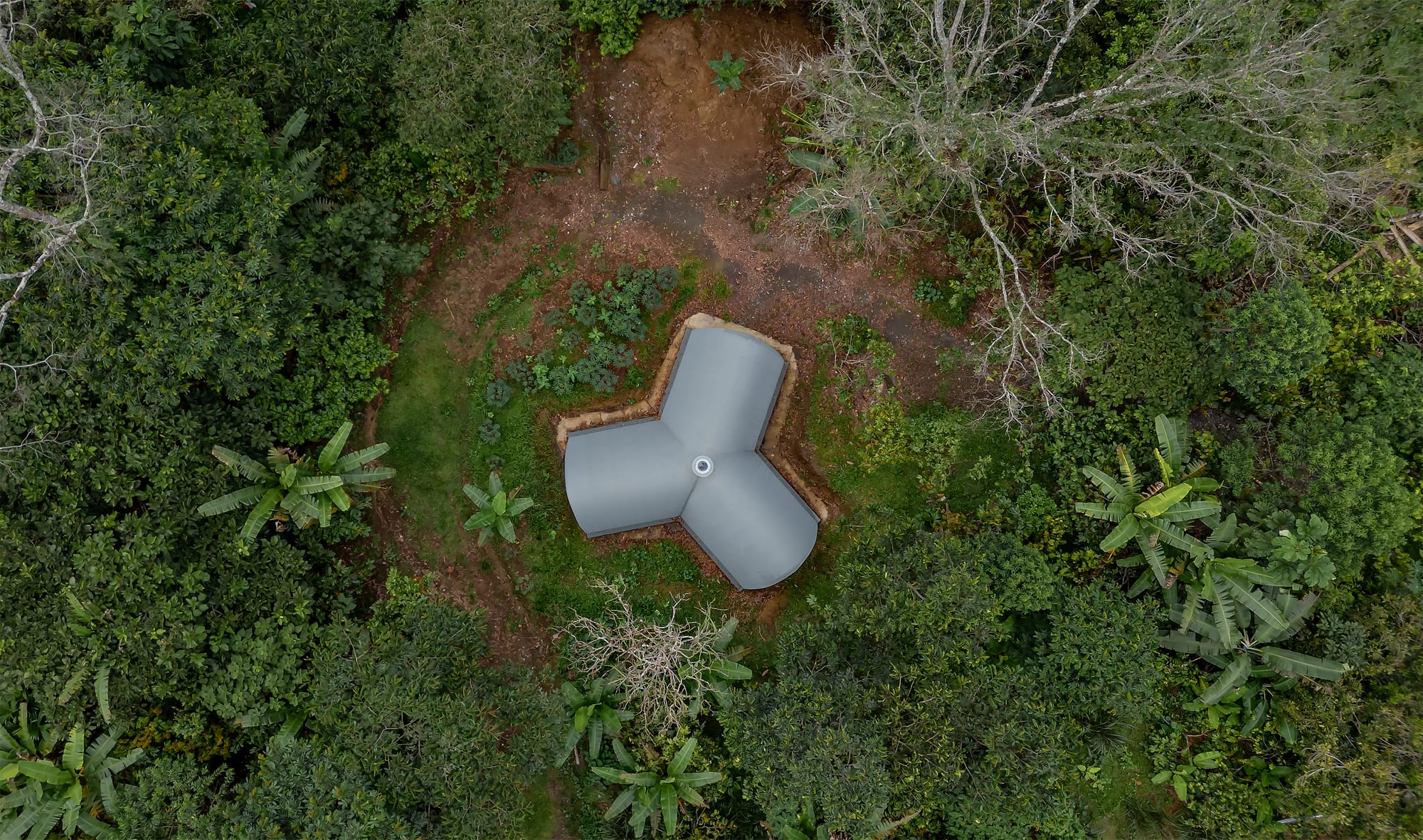 Top view on three sectioned, earth constructed laboratory surrounded by lush jungle.