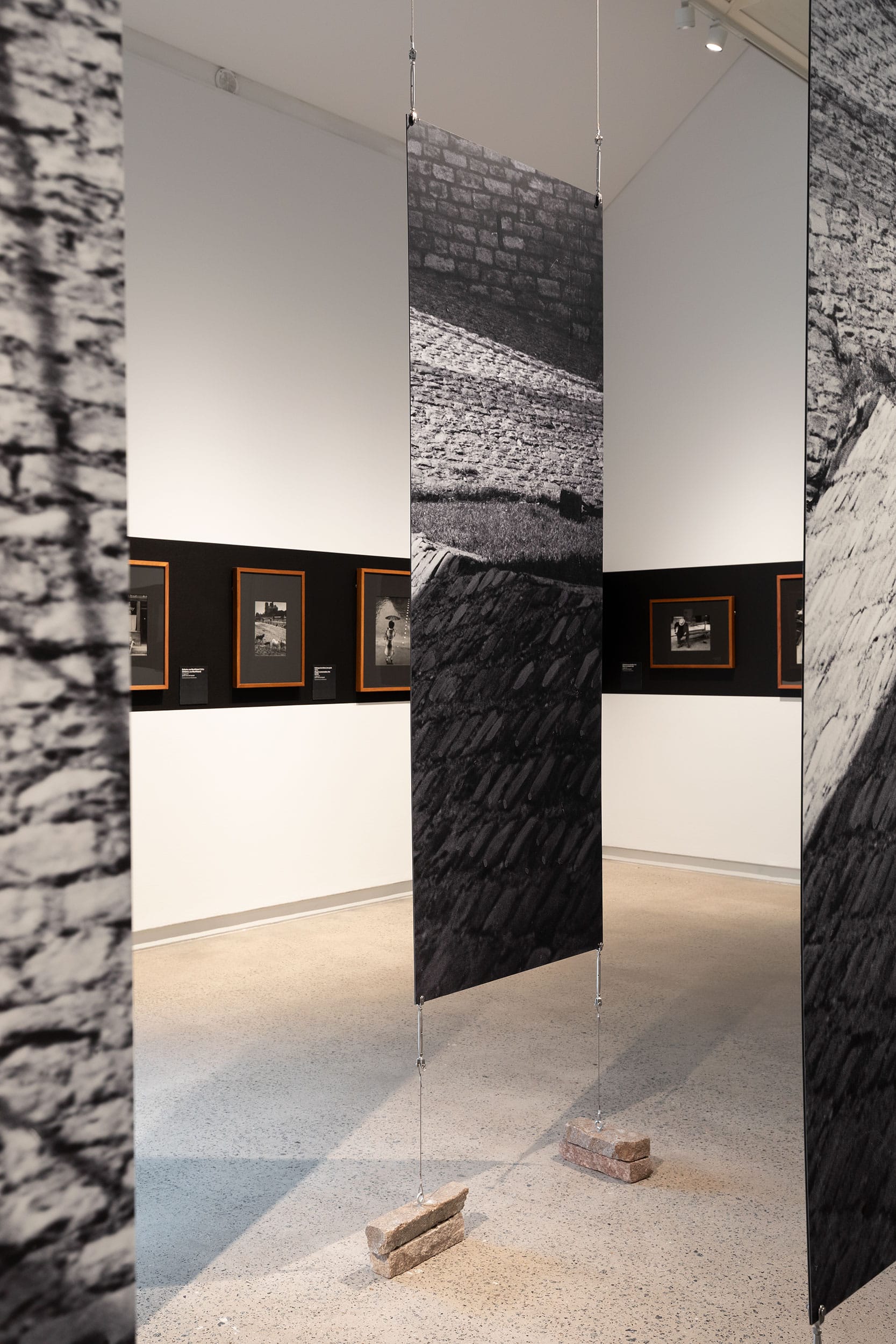 Enlarged sectioned canvas on delegate metal strings, anchored with natural stone.