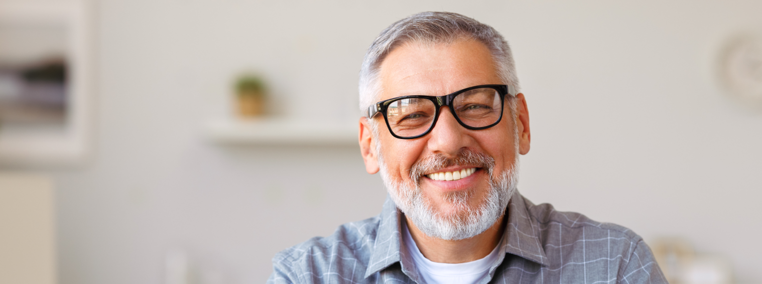Ein Mann mit Brille lächelt.