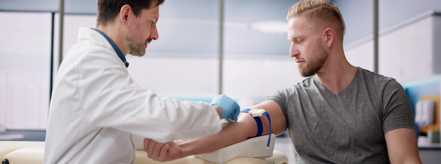 Bei einem Patienten wird Blut abgenommen.