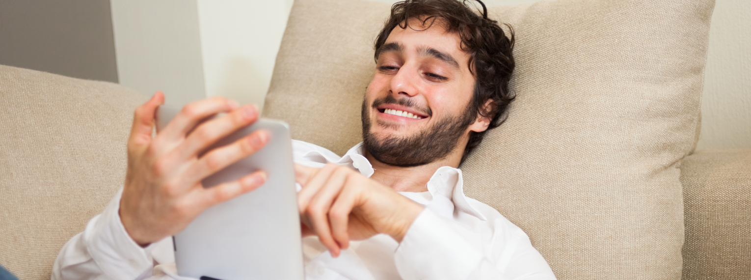 Ein Mann recherchiert auf seinem Tablet nach Hörgeräten.