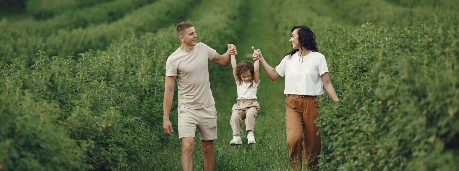 Eine Familie macht im Urlaub einen Spaziergang auf einer Wiese.